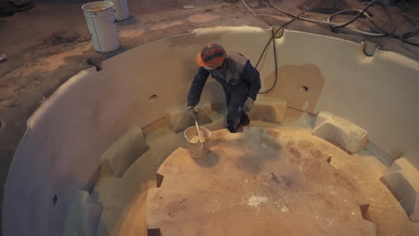 industrial worker applying resin to a mold