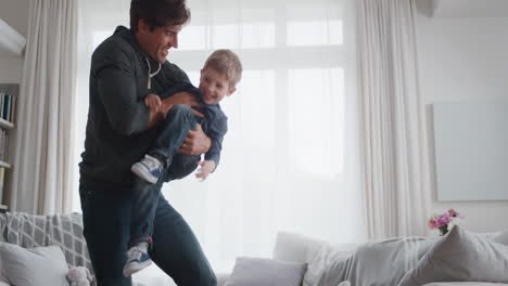 padre sosteniendo niño feliz jugando con papá en casa divirtiéndose 4k