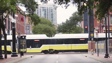 a tram crossing an empty street in downtown dallas, texas