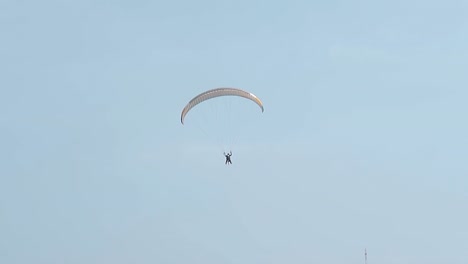 people-enjoy-paragliding-in-clear-sky-at-resort-slow-motion