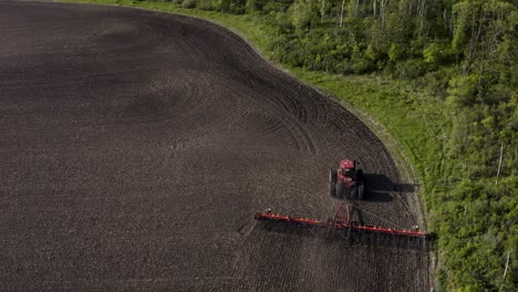 Luftaufnahme-Eines-Traktors,-Der-Ein-Großes-Unbepflanztes-Feld-Kultiviert