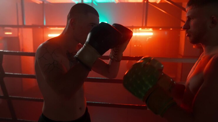 Dos boxeadores se enfrentan en un ring de boxeo iluminado con neón