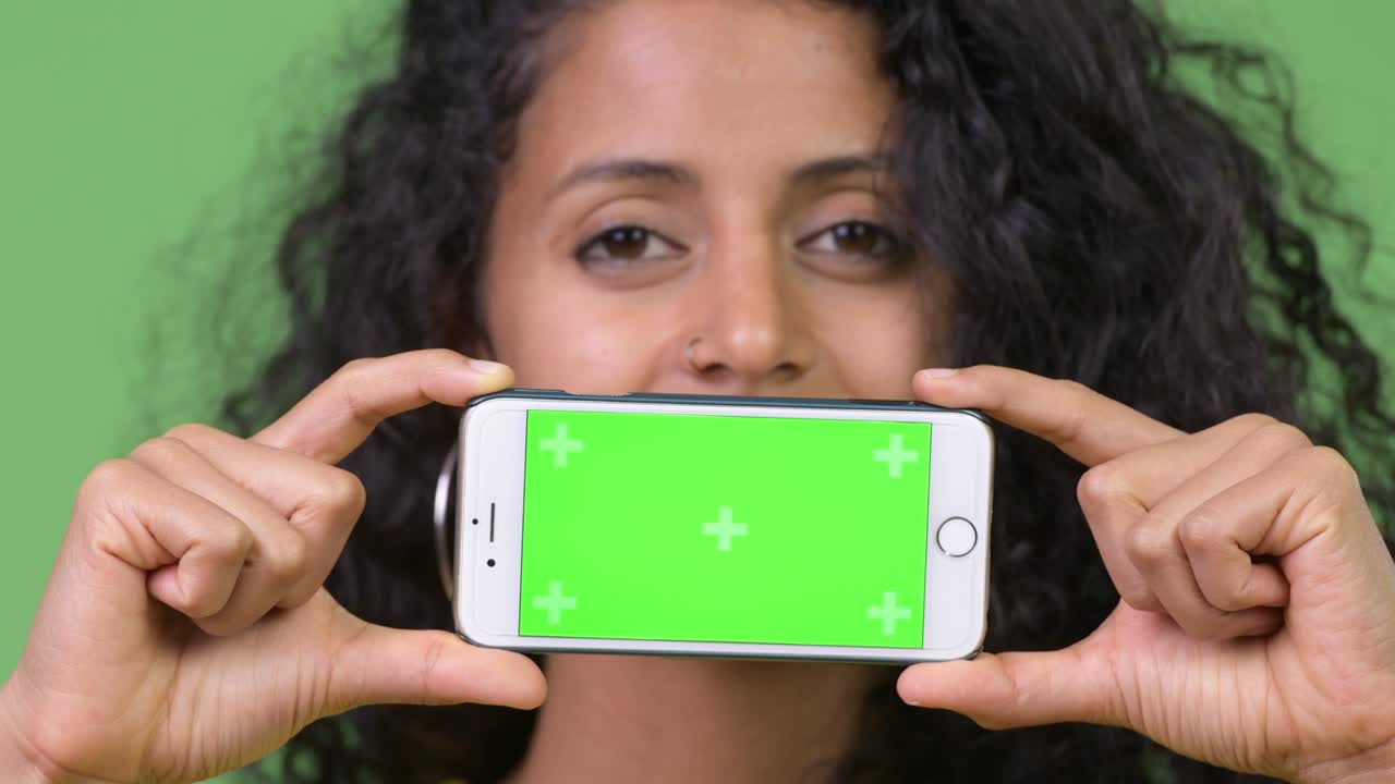 Young beautiful Hispanic woman showing phone