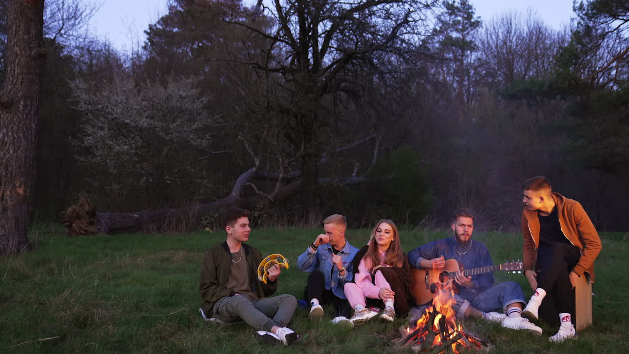 Friends Singing Around a Campfire