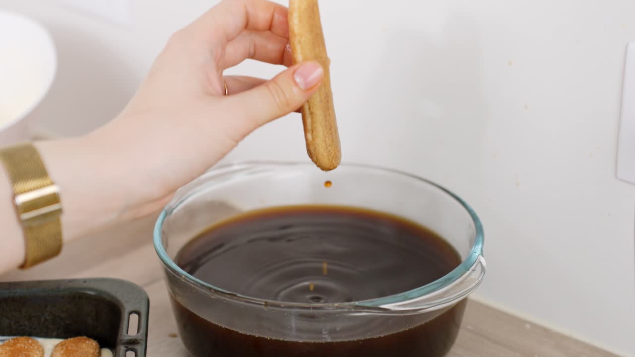 Ladyfingers are briefly dipped in coffee, a key step in layering traditional tiramisu.