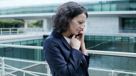 Cheerful-businesswoman-talking-by-cell-phone