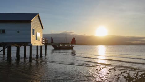 a serene sunset scene with a beach house and pier, captured in golden hour lighting, showcasing tranquil coastal beauty