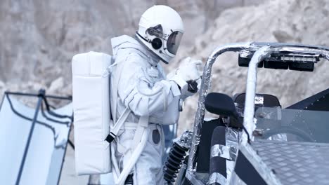 Astronauta-De-La-Nasa-Con-El-Traje-Y-El-Casco-Para-La-Cabeza-Busca-Instrumentación-En-La-Parte-Trasera-Del-Coche-Espacial