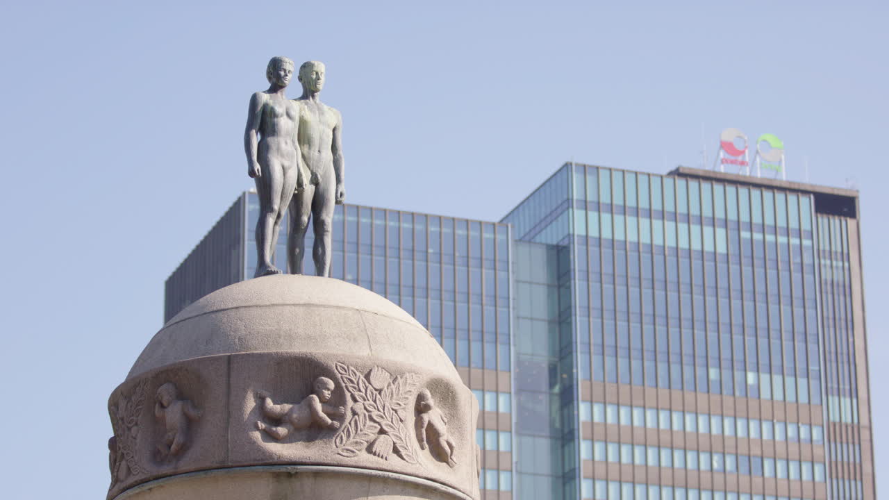 Wide shot of Ornulfs bronze sculpture by central station in Oslo, sunny summer