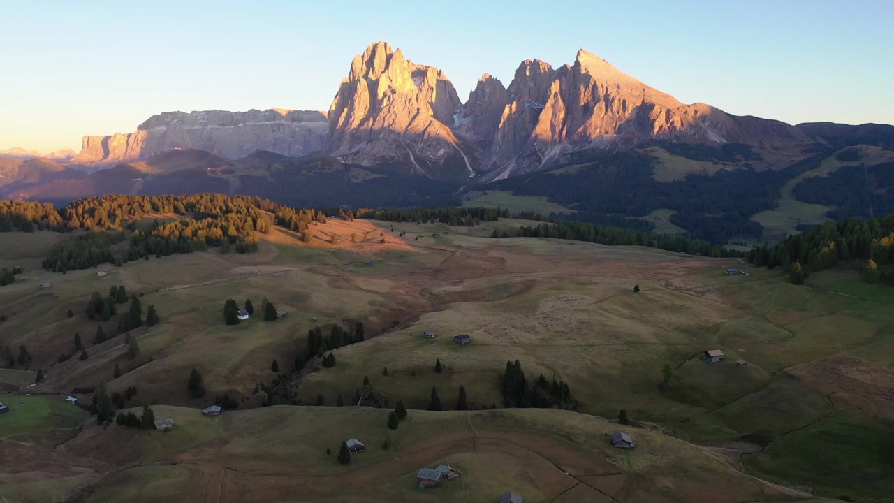 Spektakulær højvinkel droneudsigt over de ikoniske Tre Cime di Lavaredo i Italien. Viser de majestætiske tre kalkstensbjergtinder, der tårner sig op over barskt alpint terræn og vandrestier.