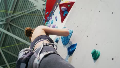 woman rock climbing on an indoor climbing wall