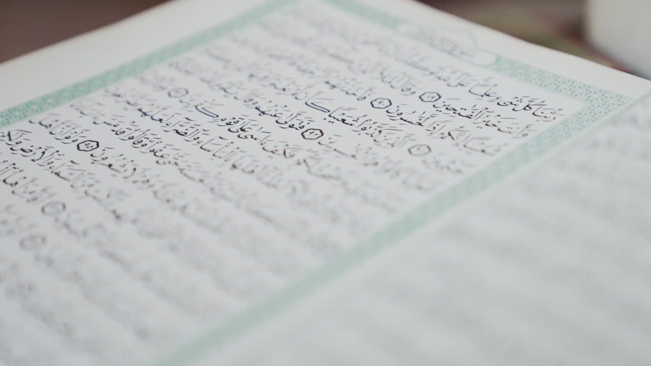 Close up on Arabic book in mosque as pages are turned in slow motion