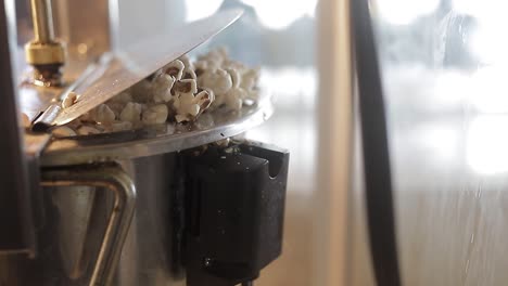 close shot of popcorn coming out of pop corn machine