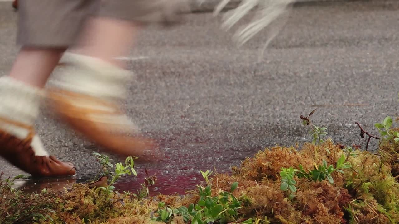 los pasos y los pies de una bailarina folclórica son visibles en un piso de madera, mostrando movimientos de danza tradicional