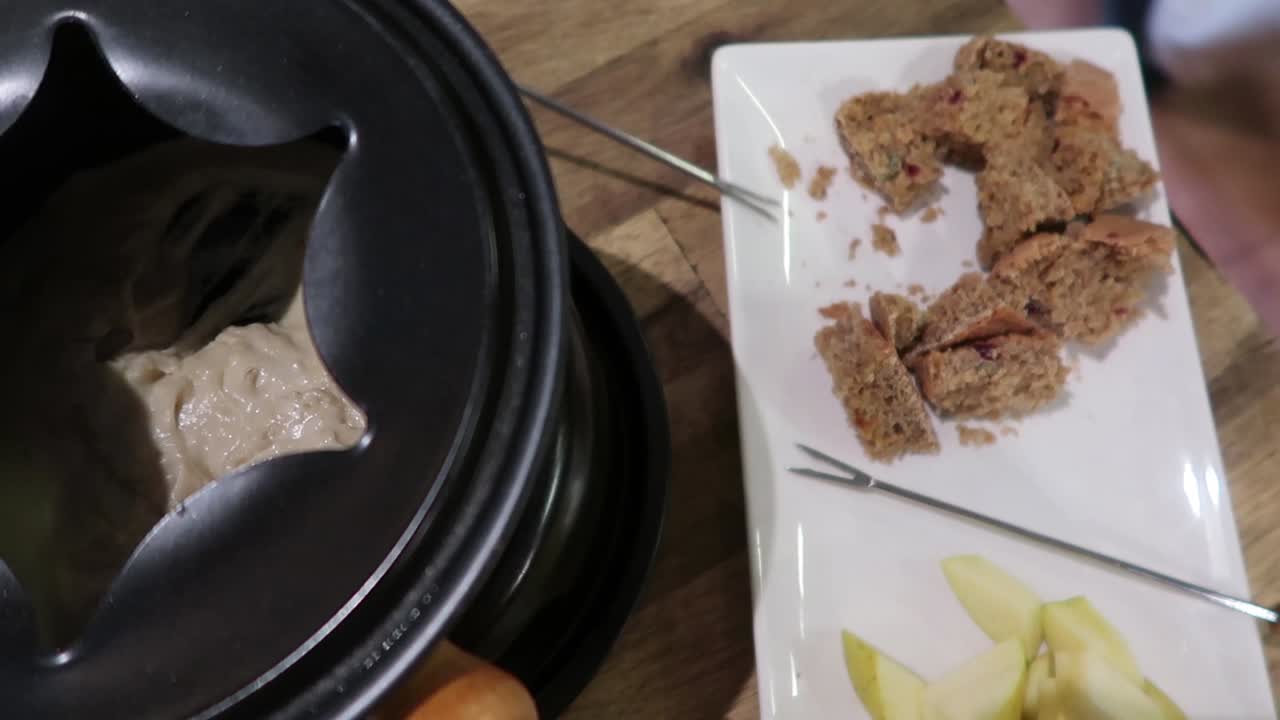 빵과 사과를 퐁듀에 찍어 먹는 남자