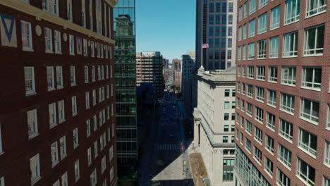 High-rise-office-buildings-in-city-business-centre.-Forwards-fly-above-street-between-red-brick-buildings.-Boston,-USA