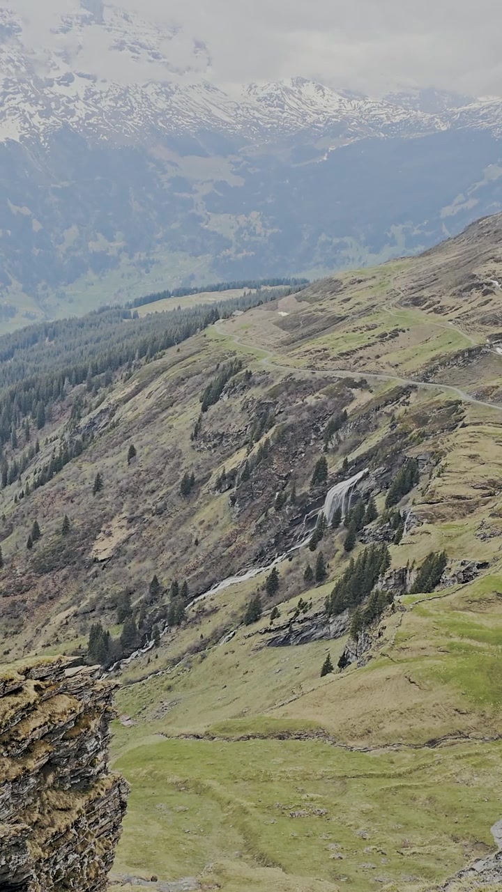 Grindelwald in Svizzera in primavera con maestose cime innevate, cascate impetuose, prati verdi lussureggianti, spettacolare paesaggio alpino. Paesaggio montano, natura incontaminata, atmosfera all'aperto