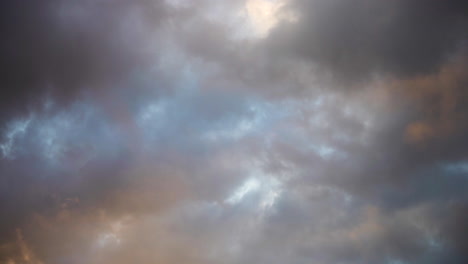 colorful clouds float passed each other in a dramatic abstract sky background