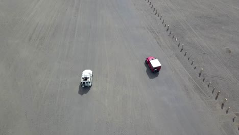 bromo volcano grey bleak landscape tourist jeep cruise - aerial fly-over follow shot