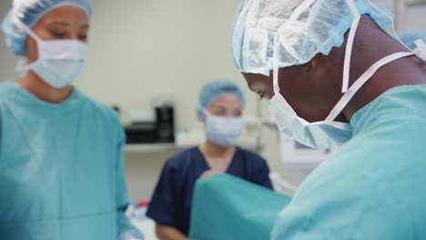 surgical team working on patient in hospital operating theatre