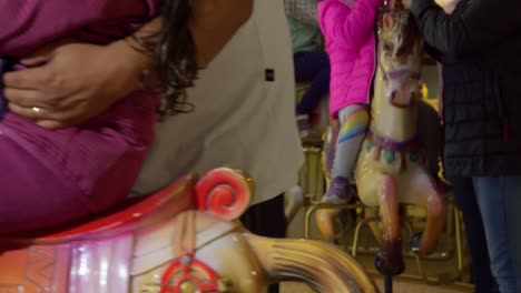 slowmotion close up of carousel with children riding wooden horses