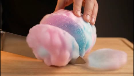 cutting a multi-colored glitter cotton candy ball