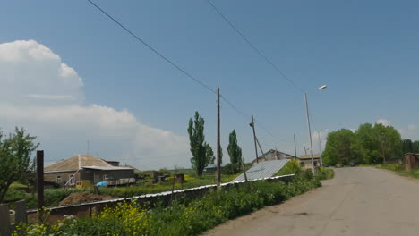 driving on the street in georgian village through rural houses