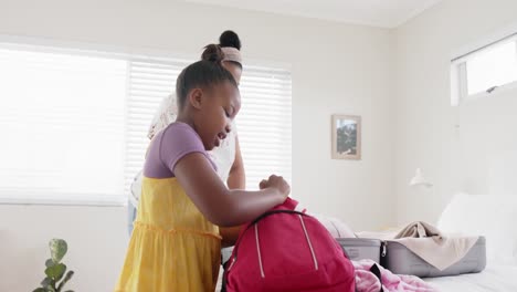 Feliz-Madre-E-Hija-Afroamericanas-Inalteradas-Empacando-Para-Un-Viaje,-Cámara-Lenta