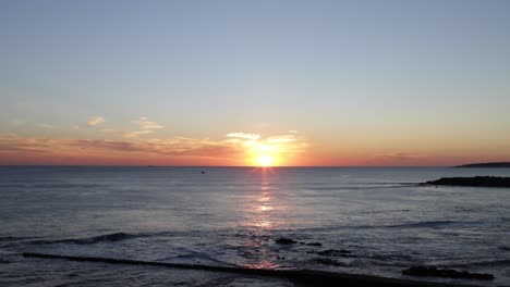 increíble puesta de sol sobre el mar con surfistas y barcos