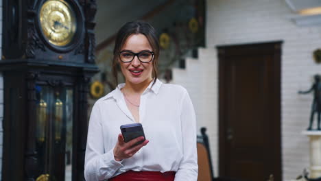 portrait of business woman in hotel. beautiful young lady in stylish glasses making a phone call on luxury background indoors.