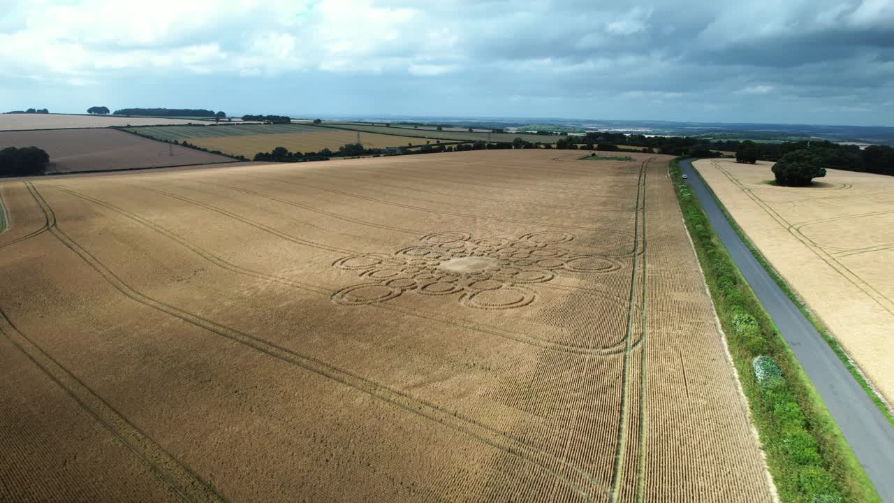 High wind blowing across Beauworth 2023 crop circle pattern pressed into Hampshire wheat field, Aerial view across farmland
