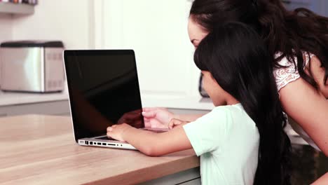 madre y su hija usando una computadora portátil