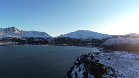 Breathtaking view of snowy mountains and a tranquil lake under sunlight in Caviahue, Neuquén, Argentina
