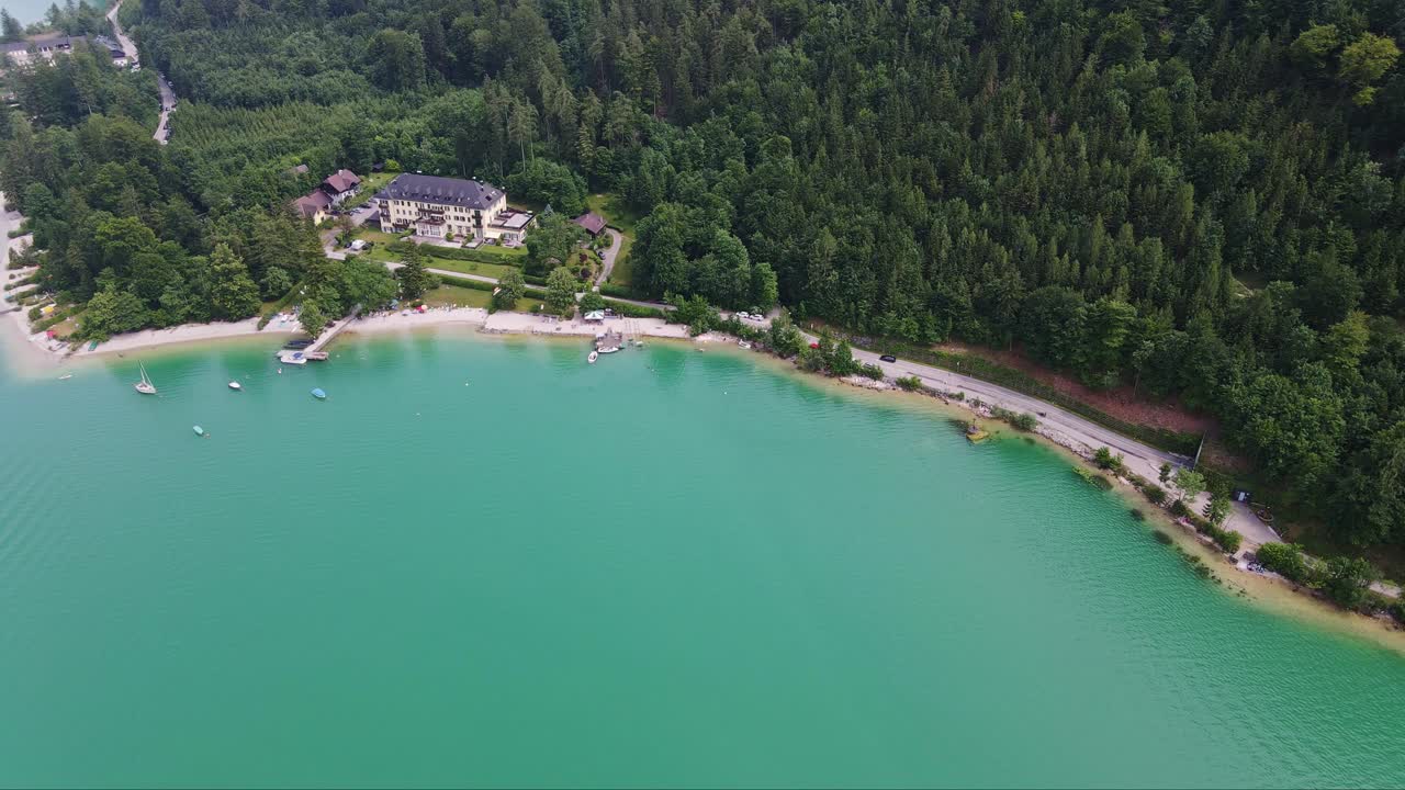 Jevn droneflyvning, turkist innsjøvann og rolig strandlinje ved Mondsee, Østerrike