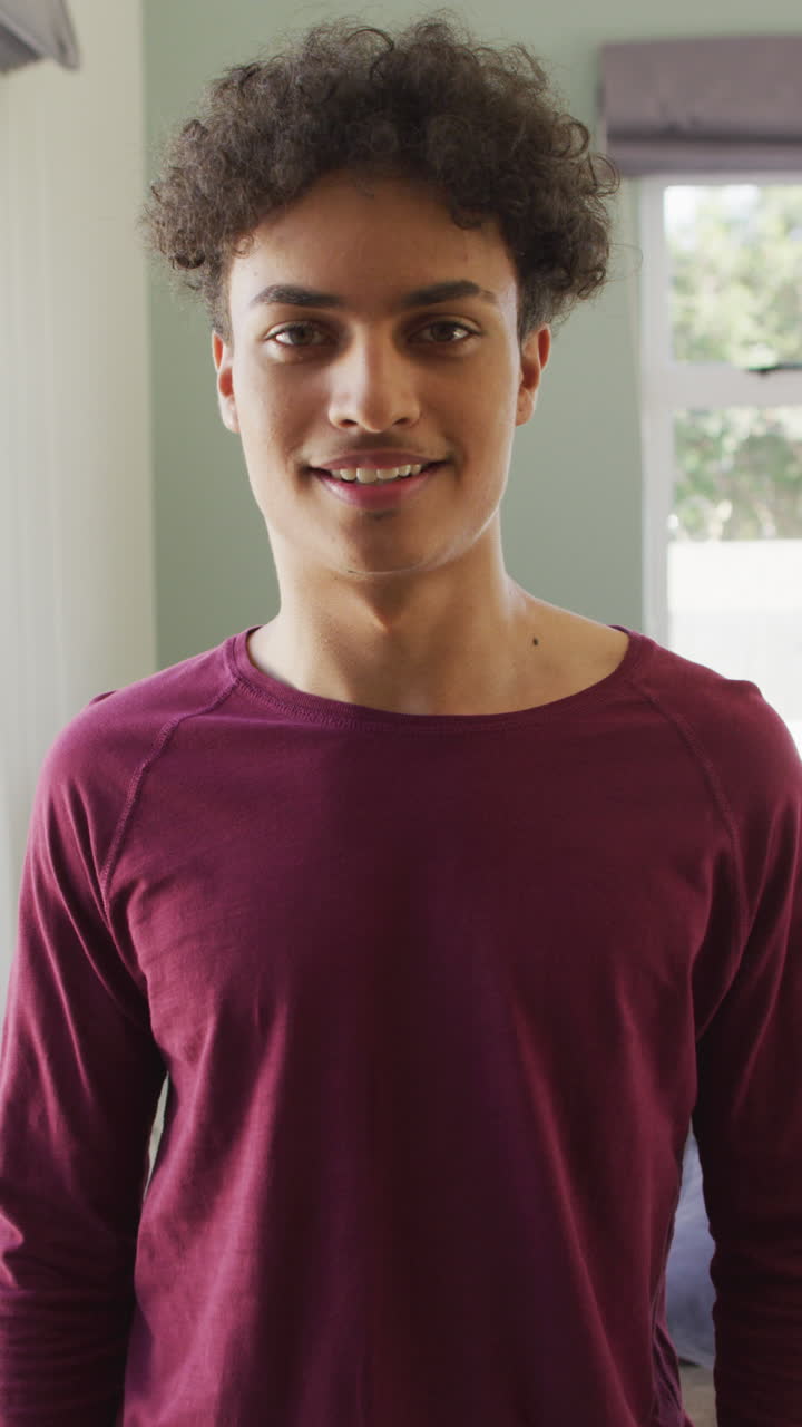 video vertical del retrato de un hombre biracial feliz en la sala de estar
