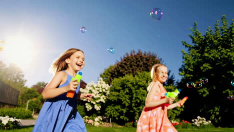 two happy girls playing with bubbles in a sunny garden