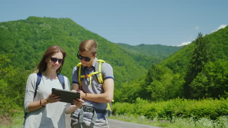 los turistas son guiados por el terreno disfrutan de la tableta que se encuentran en un lugar pintoresco en medio del monte