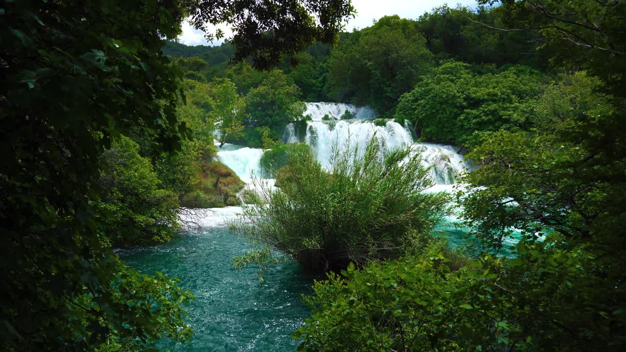 Krka National Park with flowing waterfalls, clear water cascades and green plants. Scenic springtime