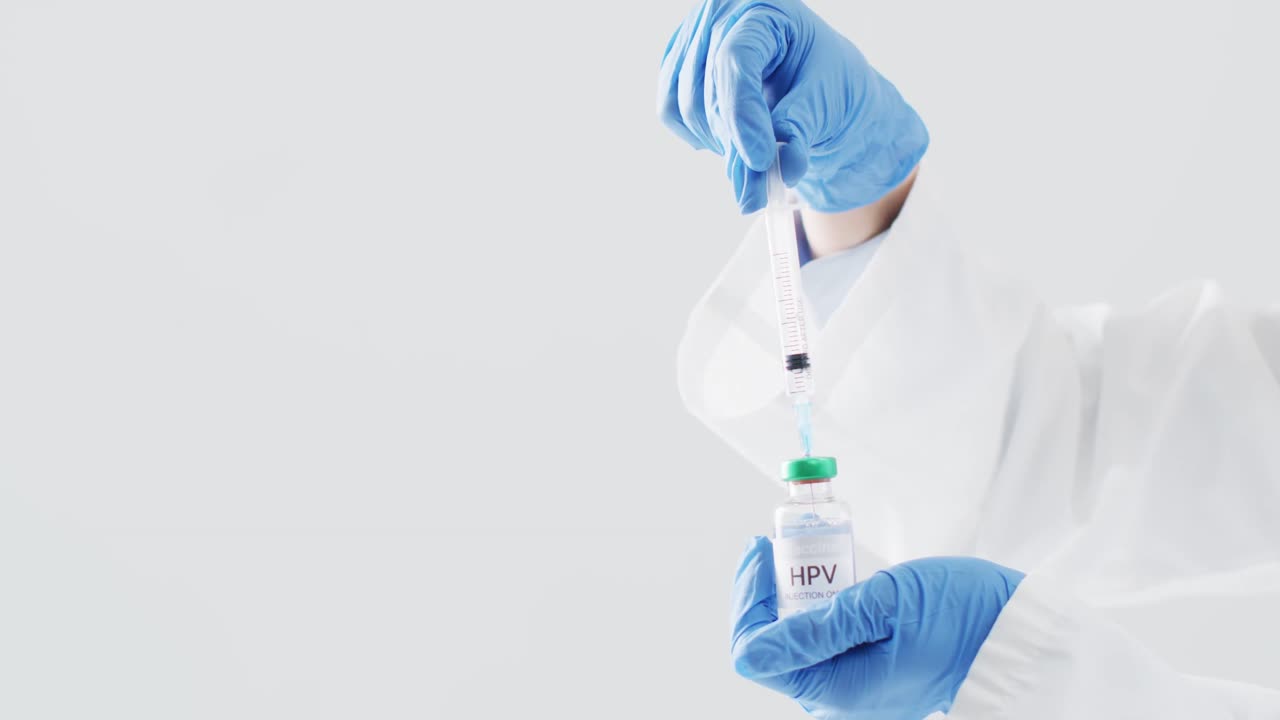 Video of hands of doctor in surgical gloves filling syringe with hpv vaccine, with grey copy space