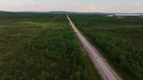 Drone-Volando-Hacia-Atrás-Frente-A-Una-Casa-Rodante-Conduciendo-En-La-Naturaleza-Boreal-Del-Norte-ártico