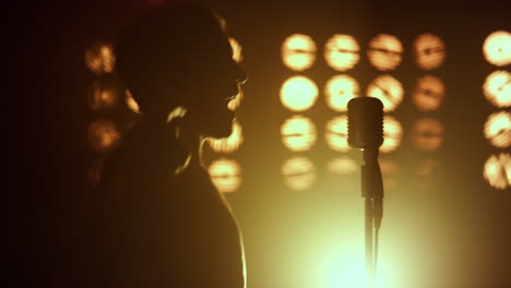 silhouette unknown performer singing in club closeup. vocalist performing firely