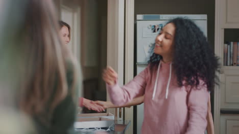 un grupo feliz de adolescentes bailando en la cocina comiendo pizza divirtiéndose celebrando juntos disfrutando de pasar el tiempo juntos en un fin de semana de fiesta