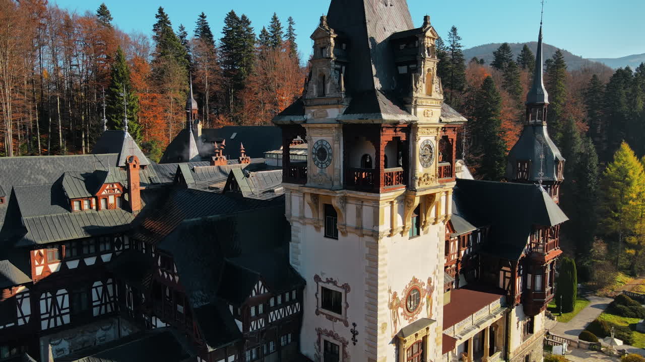 Aerial drone view of The Peles Castle in Romania. Castle with gardens in Carpathians, forest around it. Slow motion