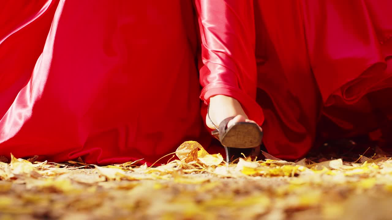 A Vibrant Dance in Autumn: Capturing the Flow of a Red Dress Amidst the Golden Leaves on a Crisp Seasonal Day