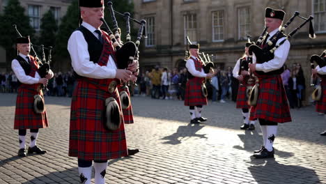 scottish bagpipe players in traditional kilts on cobblestones