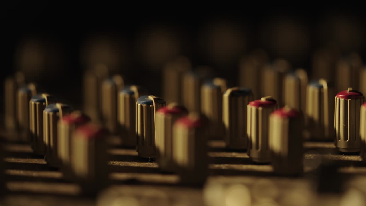 Macro d'un doigt tournant le bouton d'un potentiomètre de mixage clignotant vert et violet