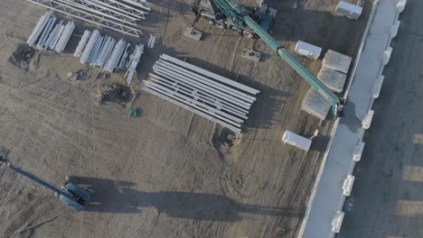 high above drone shot of crane plus material on construction site