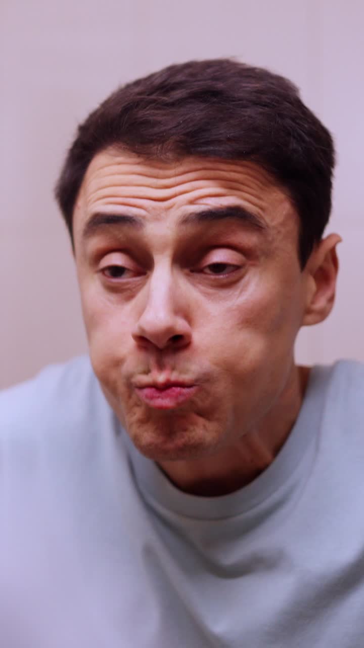 Man rinsing mouth with mouthwash in bathroom mirror