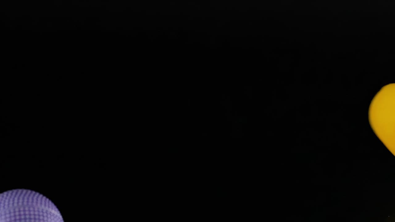 Colorful spheres move dynamically against a dark backdrop, showcasing vibrant motion and interaction.