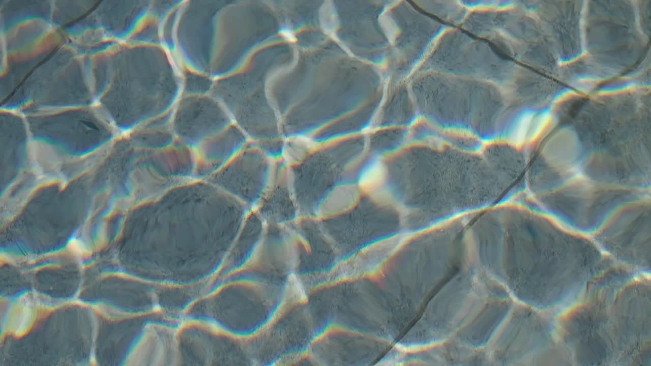 Riflessi della luce solare che creano arcobaleni sull'acqua